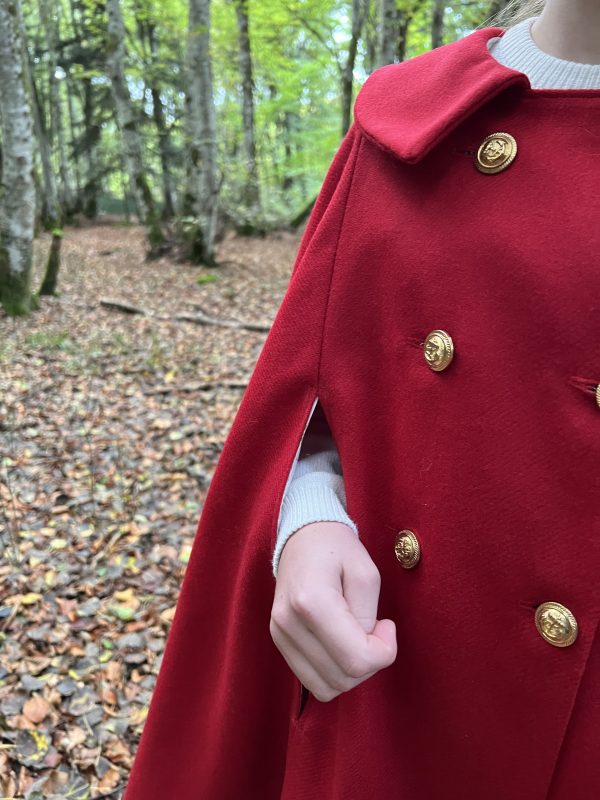 Le petit chaperon rouge se promène dans la forêt, elle porte un bonnet et une cape rouge en flanelle de laine et un panier